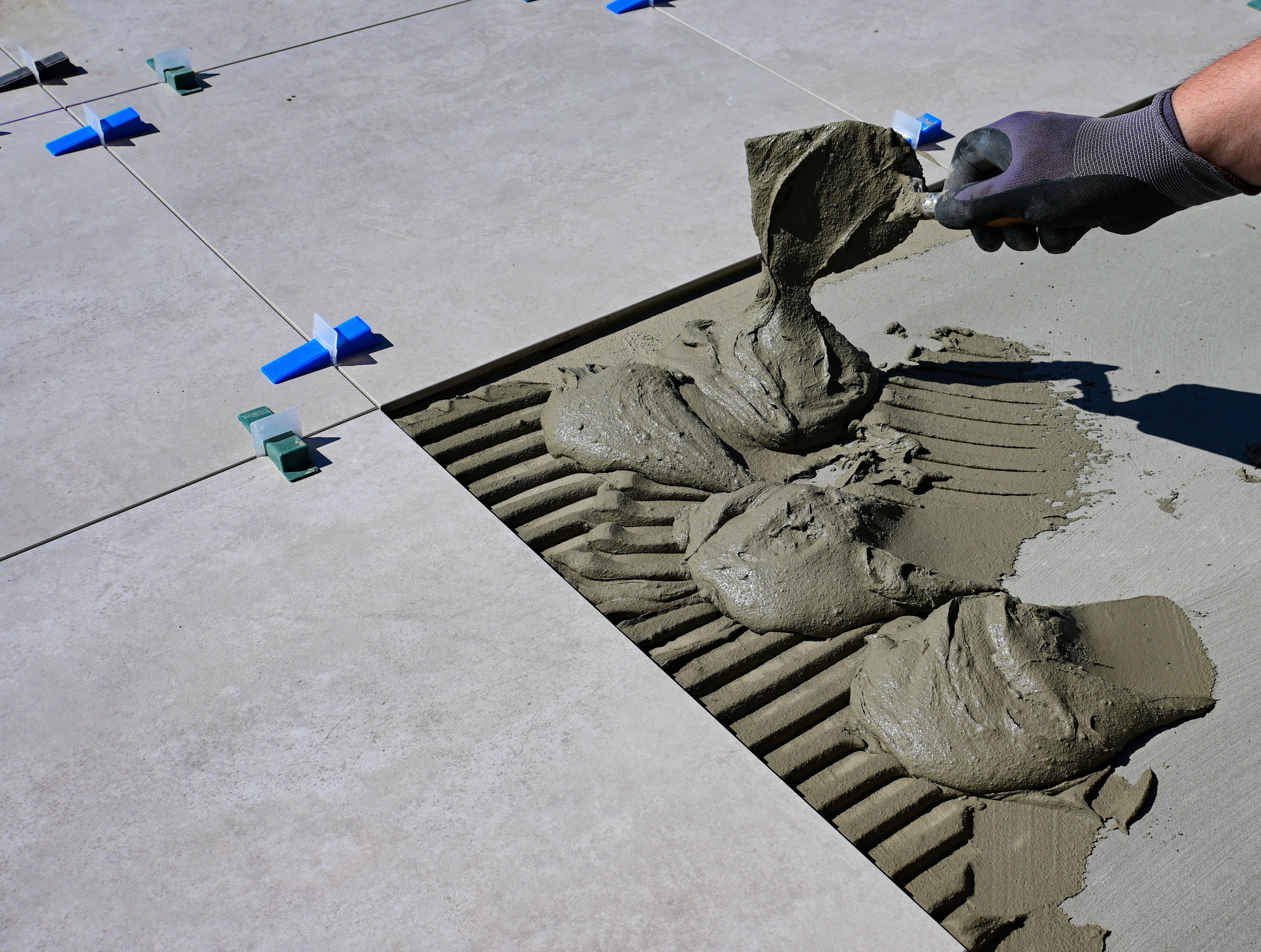 Tiling in progress — adhesive being spread on floor